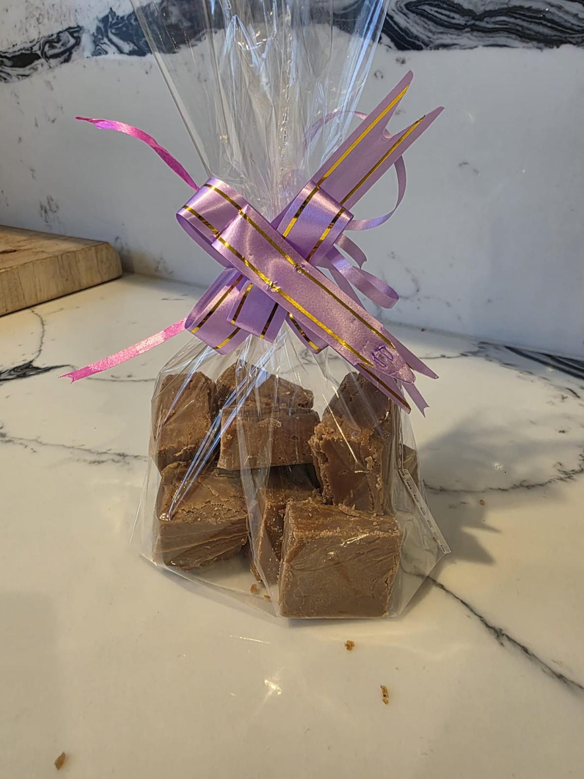 Ted’s fudge in a clear bag tied with a pink and gold ribbon